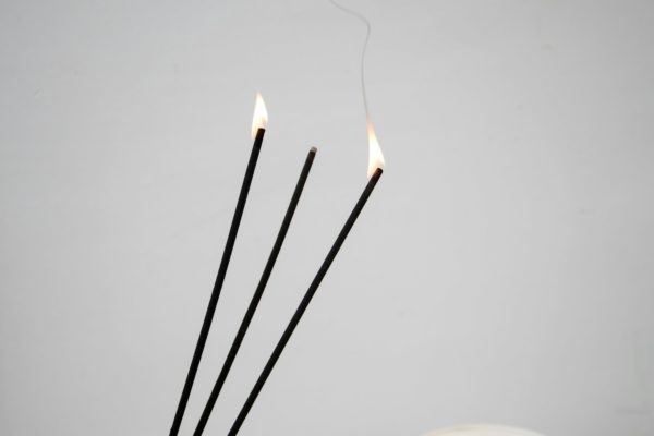 Incense sticks burning with smoke.